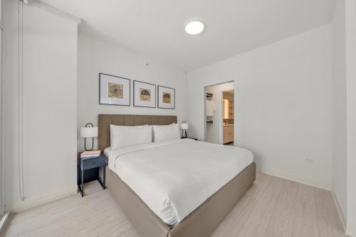 a white bedroom with a large white bed in a room at Level Chicago - Fulton Market in Chicago