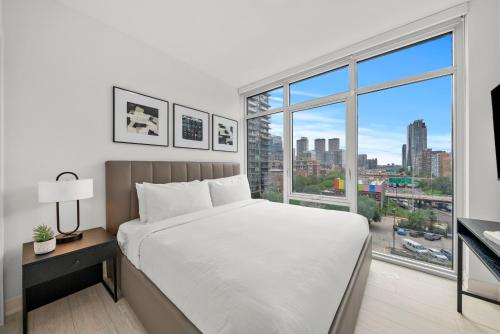 a bedroom with a white bed and a large window at Level Chicago - Fulton Market in Chicago