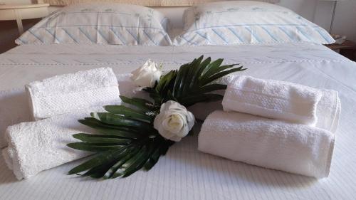 eine Gruppe Handtücher und Blumen auf dem Bett in der Unterkunft CENTRAL ROOM with private bathroom, no smoking in Palau