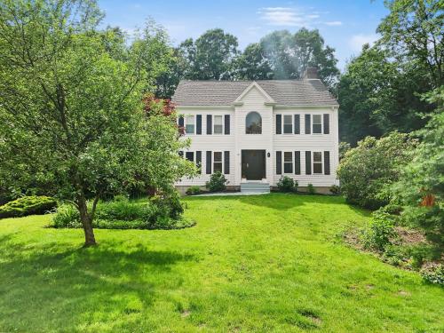 a white house with a yard with a tree at 21 Moon Compass Lane Sandwich - - Moon Compass Escape in Sandwich
