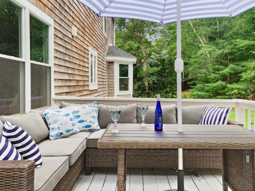 a patio with a table and an umbrella at 21 Moon Compass Lane Sandwich - - Moon Compass Escape in Sandwich