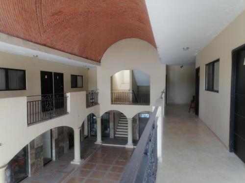 - un couloir dans un bâtiment avec une arche et des escaliers dans l'établissement Galería Concordia, à Antiguo Tamuín