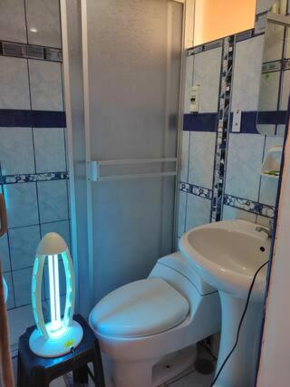 uma casa de banho com um WC branco e um lavatório. em Cozy apartment in cusco em Cusco