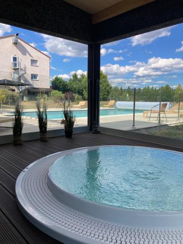 una grande vasca immersione ad acqua fredda su una terrazza con una grande finestra di Artémis Hôtel & Spa Bistro Coquet a Brioude