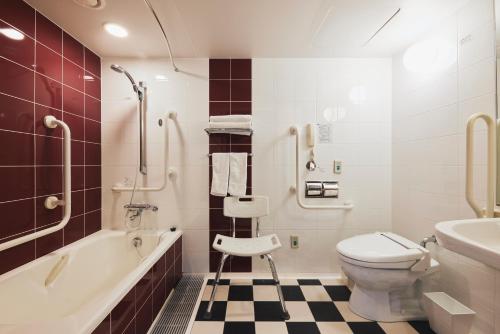 a bathroom with a toilet and a tub and a sink at Richmond Hotel Nagasaki Shianbashi in Nagasaki