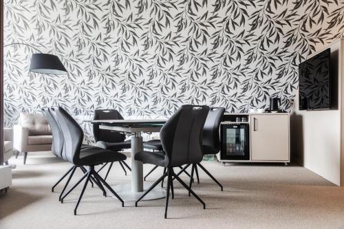 a dining room with a table and chairs and a wallpaper at Hotel Haberkamp in Achim