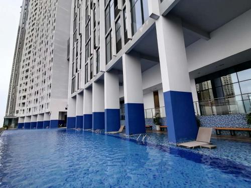 een groot gebouw met blauwe en witte zuilen en een zwembad bij ImPian 1BR condo in Phnom Penh