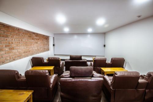 a room with leather chairs and a projection screen at Hacienda del Valle Sagrado in Urubamba