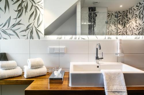 a white bathroom with a sink and a mirror at Hotel Haberkamp in Achim