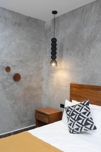 a bedroom with a bed and aendant light at Hotel Sun Ha Bacalar in Bacalar