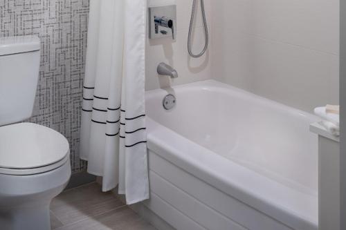 a bathroom with a white tub and a toilet at St. Petersburg Marriott Clearwater in St Petersburg