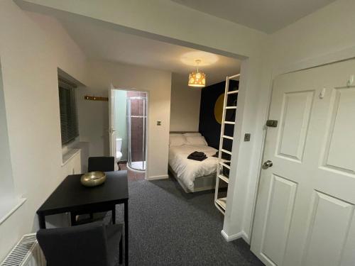 um pequeno quarto com uma cama, uma secretária e um quarto em Studio Flat em Nottingham