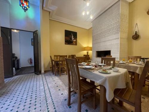 a dining room with tables and chairs and a fireplace at Riad Samarine in Marrakesh