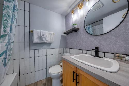 ein Badezimmer mit einem Waschbecken, einem Spiegel und einem WC in der Unterkunft Panorama Resort 2 Bedroom Creekside Condo in Panorama
