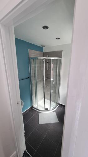 a walk in shower in a bathroom with a tile floor at En Suite room with kitchen facilities in Nottingham