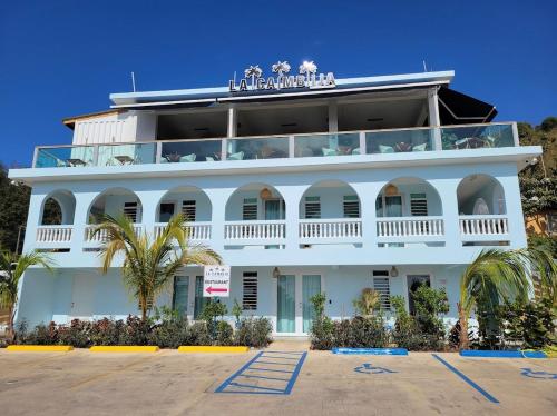 a large white building with a balcony at Tres Palmas by La Cambija in Rincon