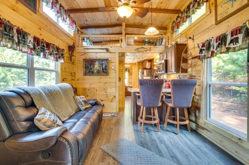 a living room with a leather couch and a table at 7 Mi to Lake Lure Mill Spring Cabin with Hot Tub in Mill Spring