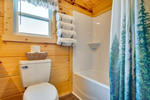 La salle de bains est pourvue de toilettes et d'une baignoire. dans l'établissement Mill Spring Log Cabin with Decks and Hot Tub!, à Mill Spring