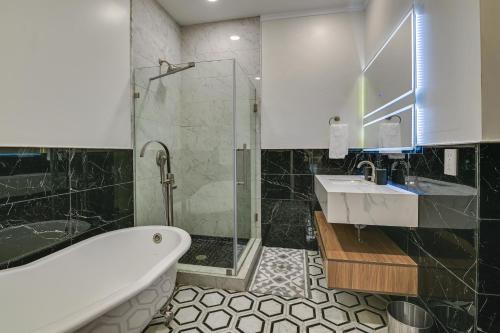 uma casa de banho com uma banheira, um lavatório e um chuveiro em Contemporary Cohoes Retreat with Electric Fireplace! em Cohoes