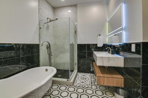 a bathroom with a tub and a sink and a shower at Contemporary Cohoes Retreat with Electric Fireplace! in Cohoes