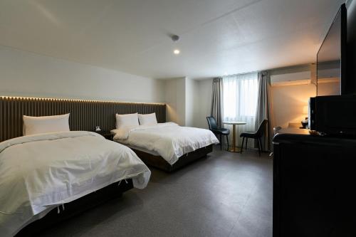 ein Hotelzimmer mit 2 Betten und einem TV in der Unterkunft Hotel Chloe in Seoul