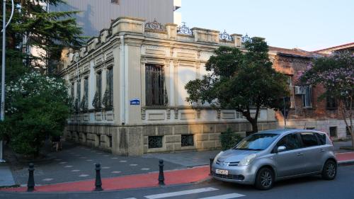 a small car parked in front of a building at Karvi Hostel & Suites in Batumi