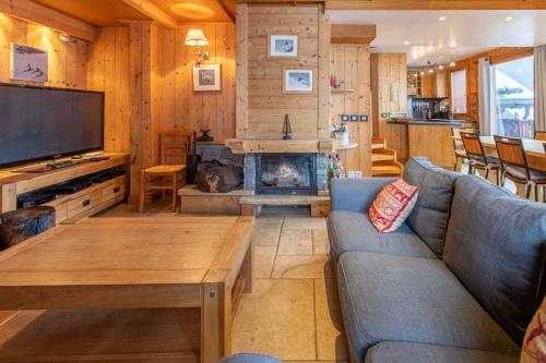 a living room with a couch and a fireplace at Chalet Clearmount with Spa in Méribel