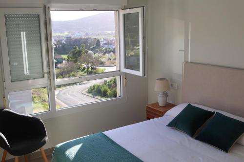 1 dormitorio con 1 cama y 2 ventanas grandes en Apartments in Vimianzo, The Heart of Costa da Morte, en A Coruña