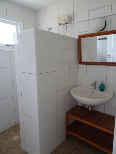 Pura Vida Aruba appartement Cama في نورد: حمام أبيض مع حوض ومرآة