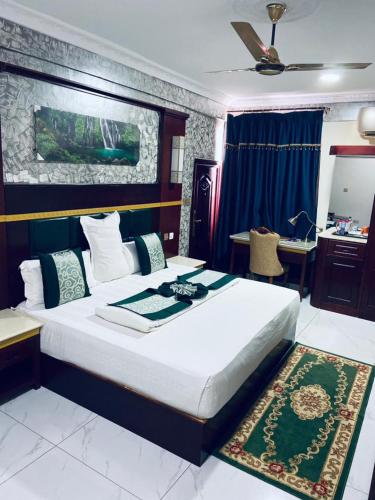 a bedroom with a large bed and a desk at Dellagio Hotel in Wa
