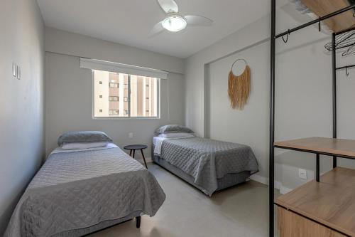 1 dormitorio con 2 camas y ventana en Apartamento Balneario Camboriu Quadra Mar, en Balneário Camboriú