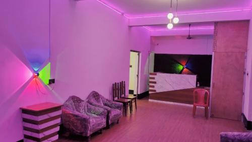 a purple room with a couch and chairs and a bedroom at Hotel The Aparna Residency in Āsansol