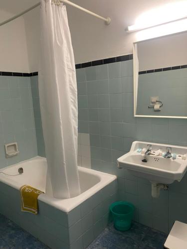 La salle de bains est pourvue d'une baignoire, d'un lavabo et d'un rideau de douche. dans l'établissement Clipper Affiliated by FERGUS, à Lloret de Mar