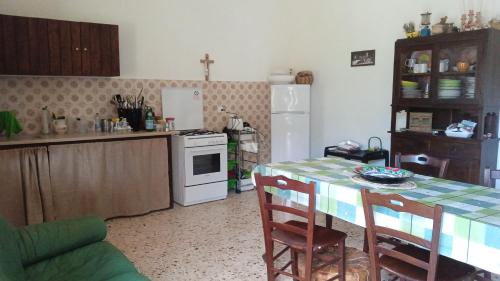 een keuken met een tafel en een witte kookplaat bij La dimora delle terme di Segesta in Castellammare del Golfo