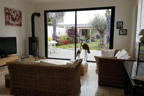 a living room with two birds standing on a couch at Chez Lily in Vélizy-Villacoublay