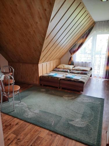 1 dormitorio con 1 cama, 1 silla y 1 alfombra en Pokoje Gościnne - Pieniny, en Sromowce Niżne