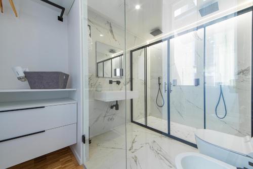 La salle de bains est pourvue d'une douche en verre et d'un lavabo. dans l'établissement cavaedium guest house, à Arona