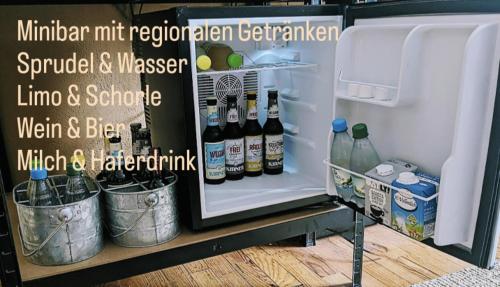 an open refrigerator filled with bottles and drinks at Landhaus Spanier in Nonnweiler