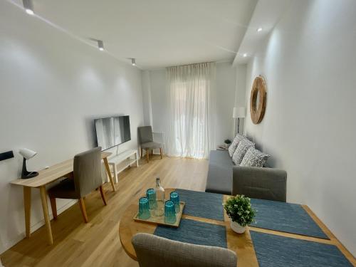 a living room with a table and a couch at NEW CAPUCHINOS Apartment 1 in Málaga