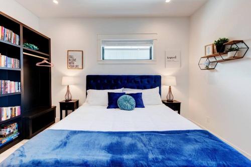 a bedroom with a blue and white bed and bookshelves at New Luxury Villa and Private Pool-Cart-Ocean View! in Port Aransas