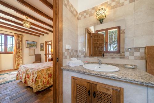 uma casa de banho com um lavatório e uma cama num quarto em Villa San Nicolas - private, tranquil, relaxing.. em Ermita Nueva