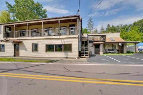 a white building with a balcony on a street at Second-Floor Harveys Lake Apartment with Deck! in Harveys Lake
