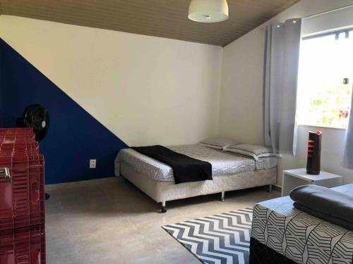 1 Schlafzimmer mit 2 Betten und einer blau-weißen Wand in der Unterkunft Juiz de Fora, casa linda com piscina, sauna e lareira in Juiz de Fora