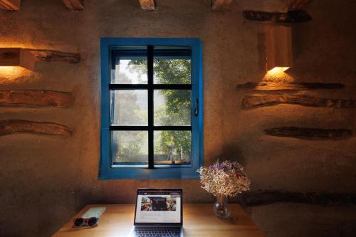 下米拉諾瓦茲的住宿－Zeleni zaliv-The Green Bay，坐在窗前桌子上的笔记本电脑