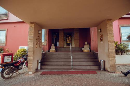 a building with stairs leading to a building with statues at Noble House Hotel in Kumasi