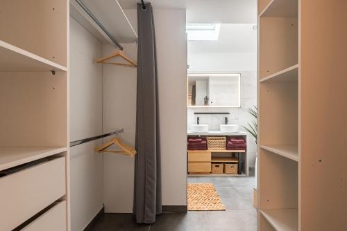 a walk in closet with white walls and wooden closets at Charmante Maison Climatisée avec son Jardin à 10 minutes de DIJON in Marsannay-la-Côte