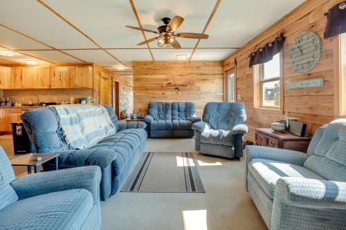 a living room with blue furniture and wooden walls at Toivola Home with Fire Pit 8 Mi to Lake Superior! in Toivola