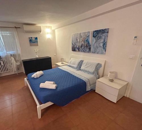 a bedroom with a blue bed with towels on it at A Quattro Passi Dalle Mura in Lucca