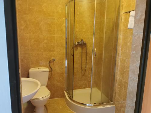 ein Bad mit einer Dusche, einem WC und einem Waschbecken in der Unterkunft Siedlisko nad stawem in Lyck