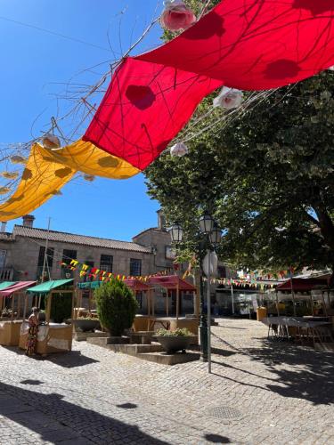 a group of red and yellow umbrellas on a street at Casa do Pelourinho in Belmonte